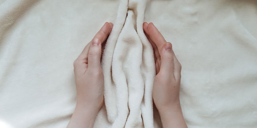 Woman holding towel in the shape of a labia